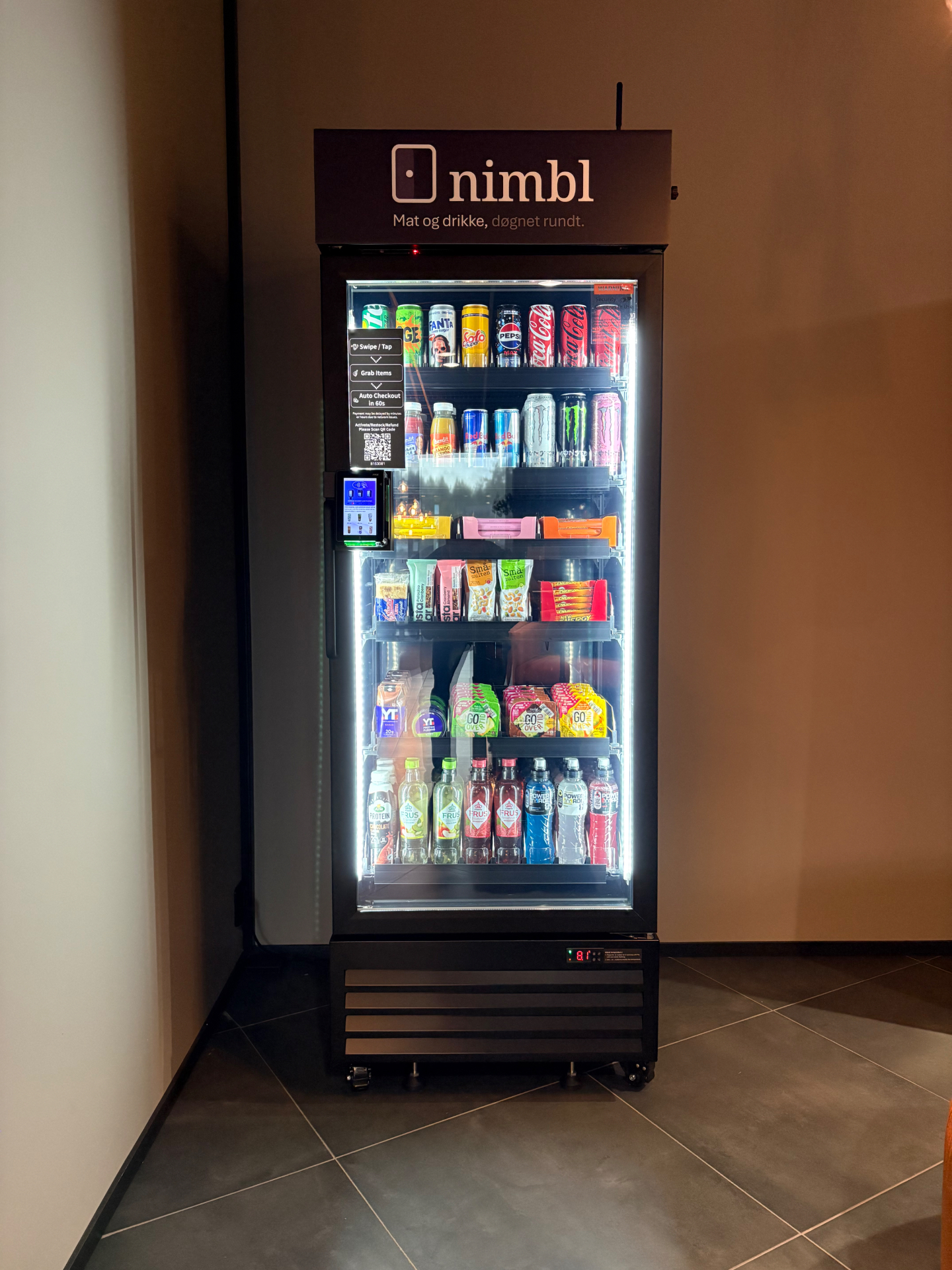 Nimbl smart kjøleskap med glassdør fylt med norske drikkevarer og snacks, plassert i et moderne innemiljø